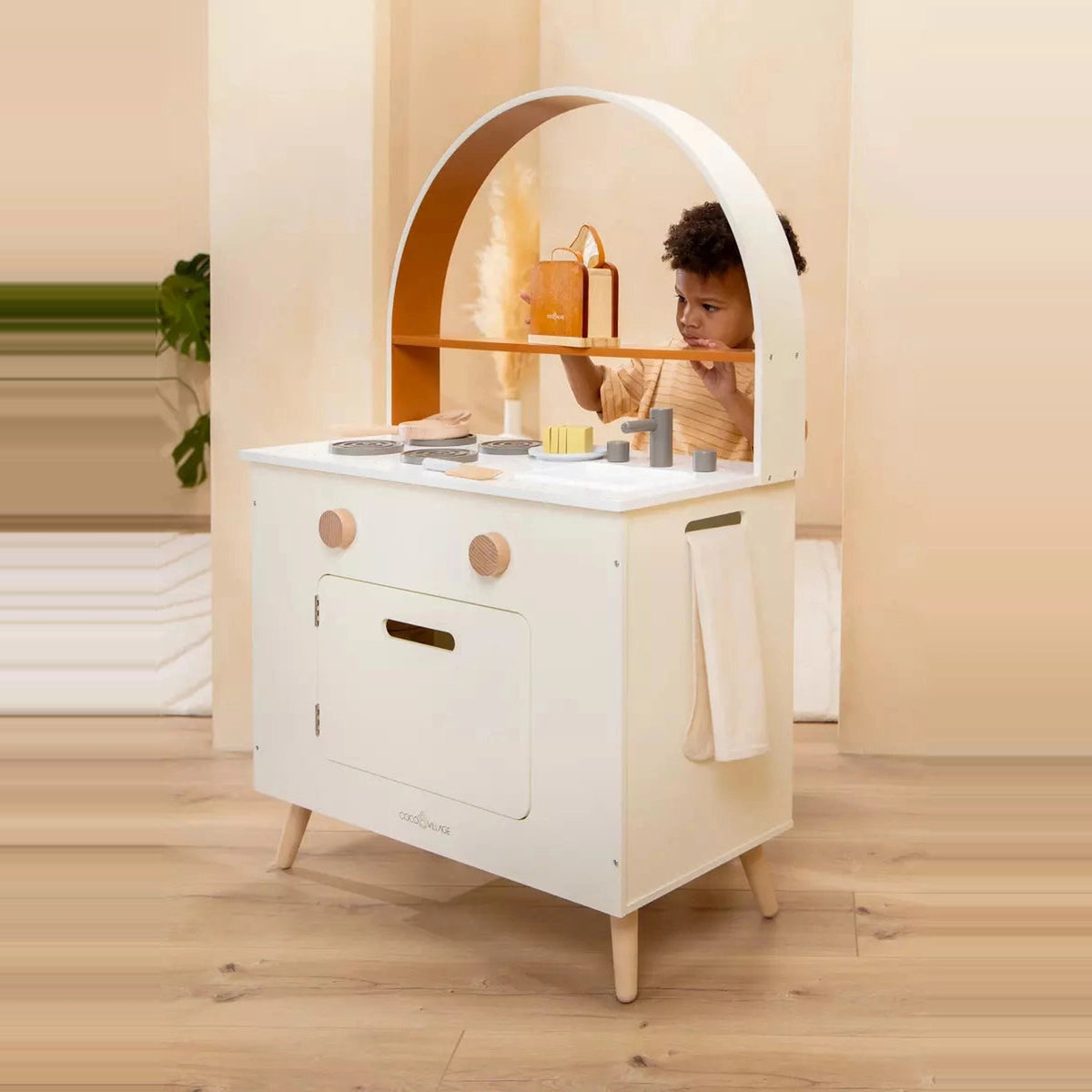 Child cooking at wooden play kitchen