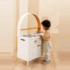 Toddler at wooden play kitchen
