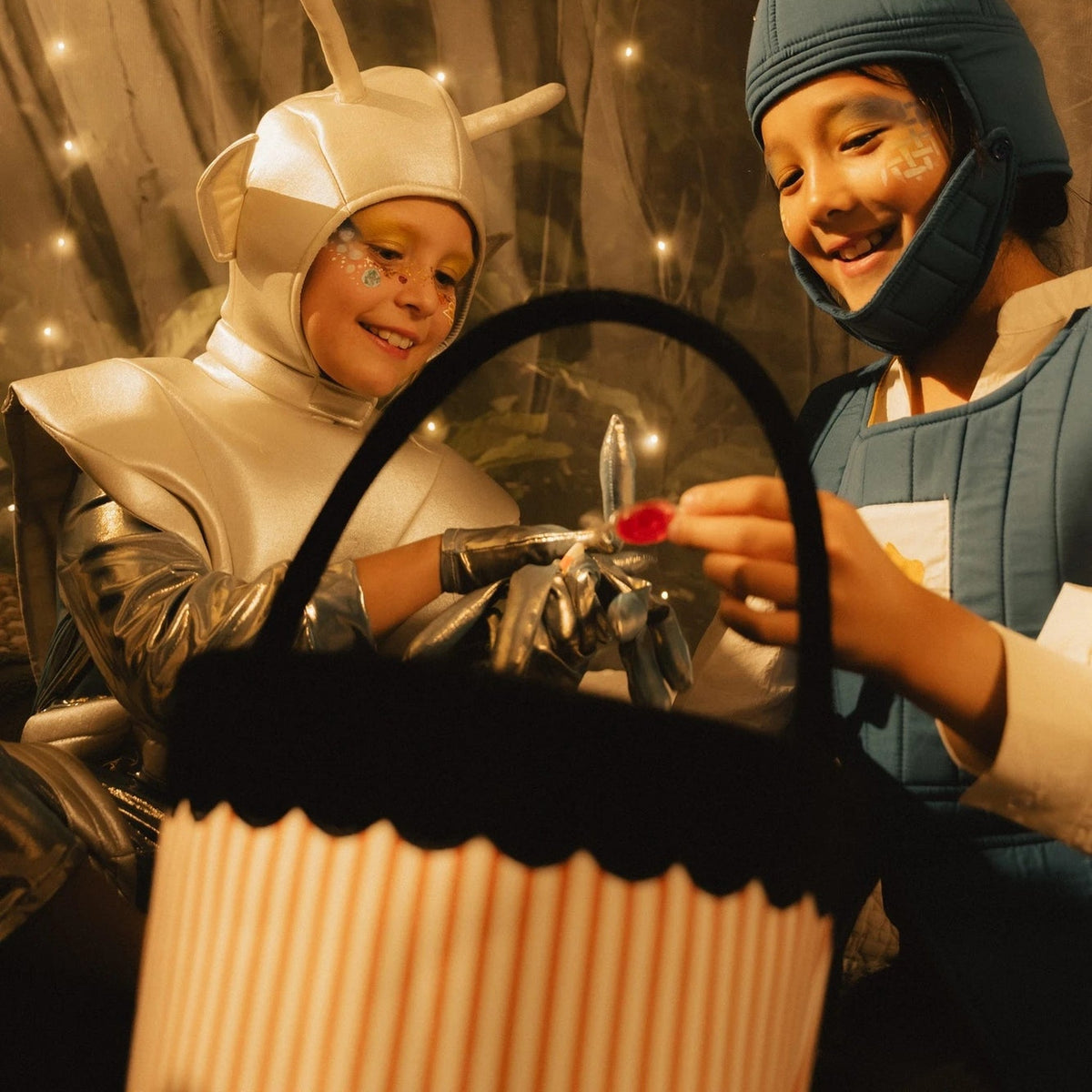 Kids trick-or-treating with the Pumpkin Stripe Treat Basket