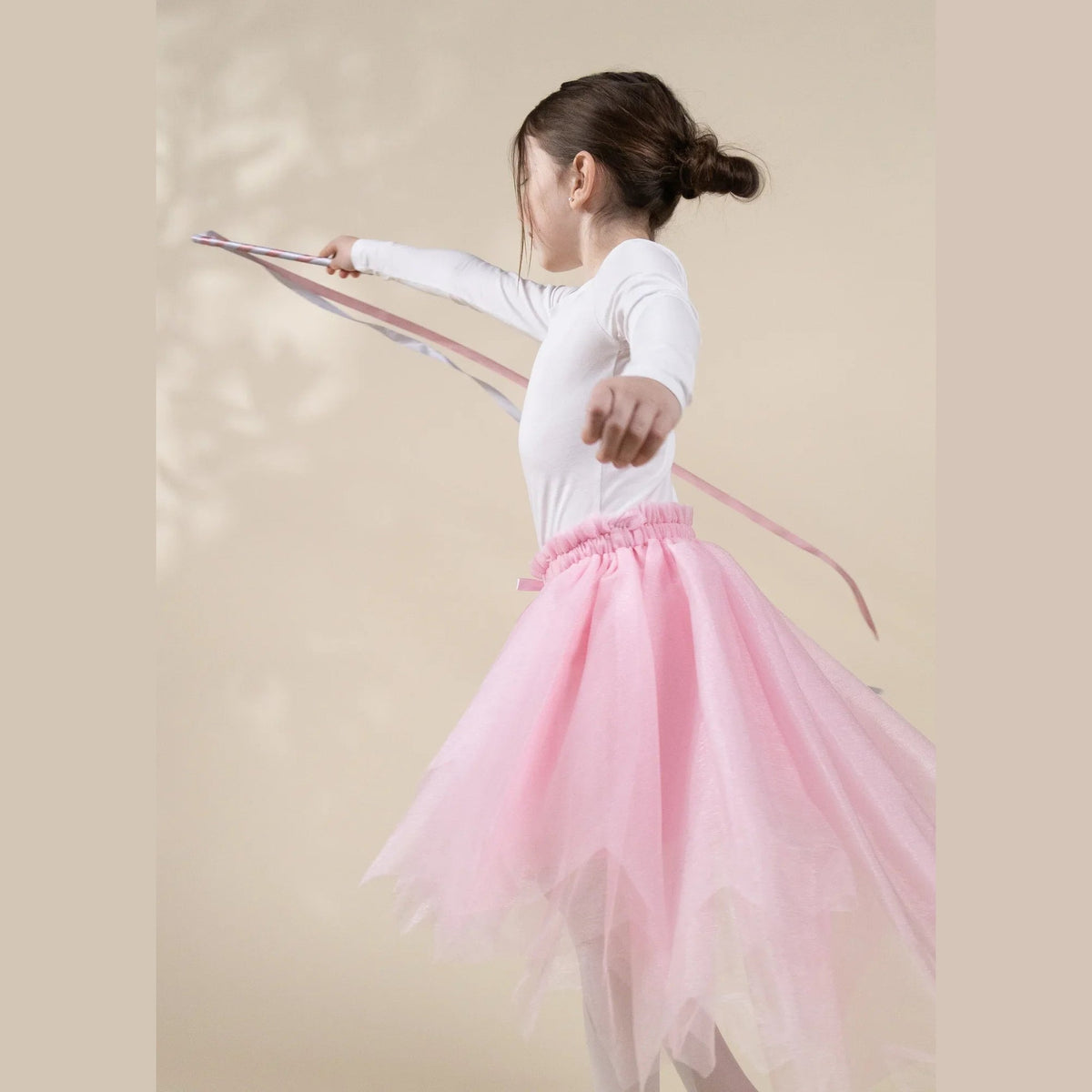 Child dancing with ribbon wand