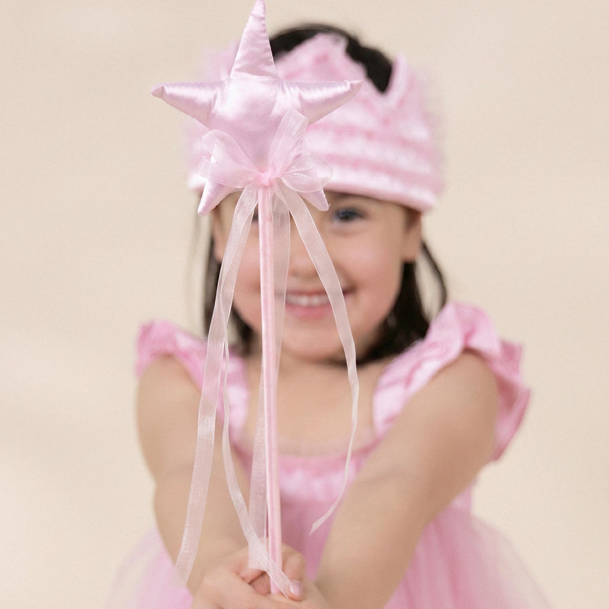 Child holding pink star wand