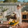 Child gardening with yellow wheelbarrow